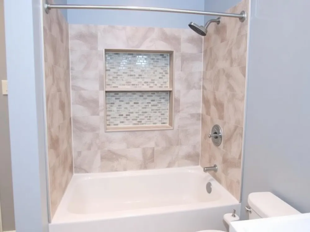 Tub-to-shower conversion in a Greensboro, NC bathroom with tiled walls and a glass panel